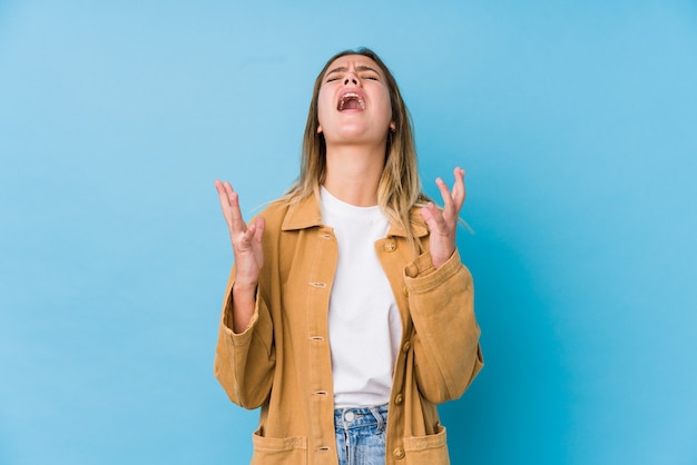 Jeune femme caucasienne criant vers le ciel, levant les yeux, frustrée.