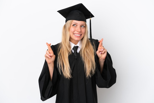 Jeune femme caucasienne diplômée universitaire isolée sur fond blanc avec les doigts qui se croisent