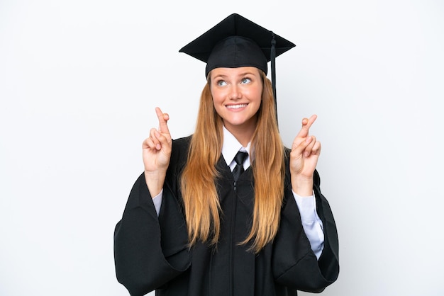 Jeune femme caucasienne diplômée universitaire isolée sur fond blanc avec les doigts qui se croisent