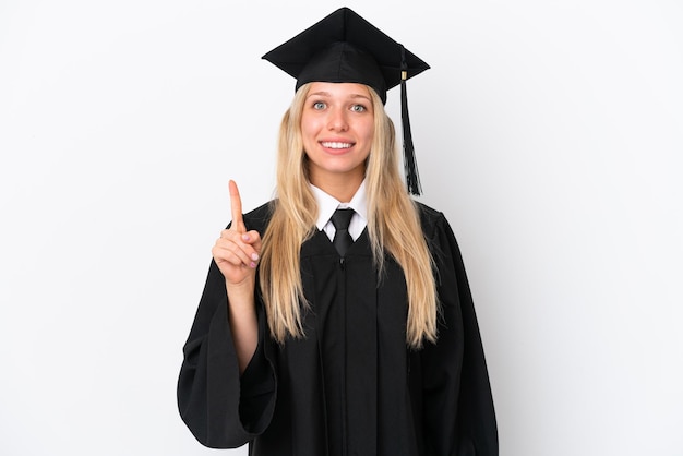 Jeune femme caucasienne diplômée universitaire isolée sur fond blanc montrant et levant un doigt en signe du meilleur