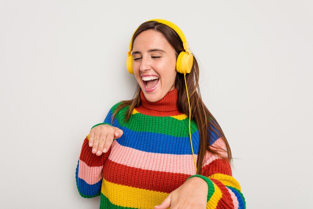 Jeune femme caucasienne écoutant de la musique avec un casque isolé sur fond blanc