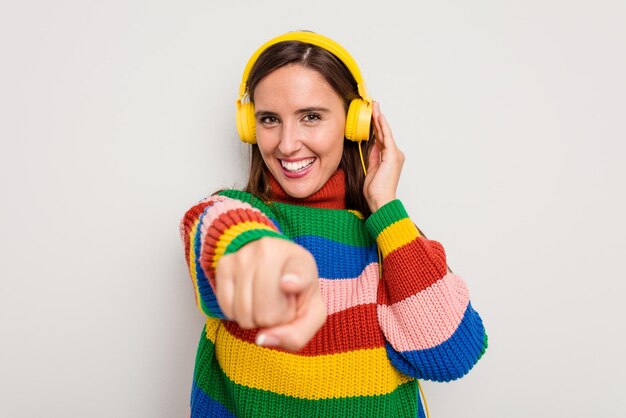 Jeune femme caucasienne écoutant de la musique avec un casque isolé sur fond blanc