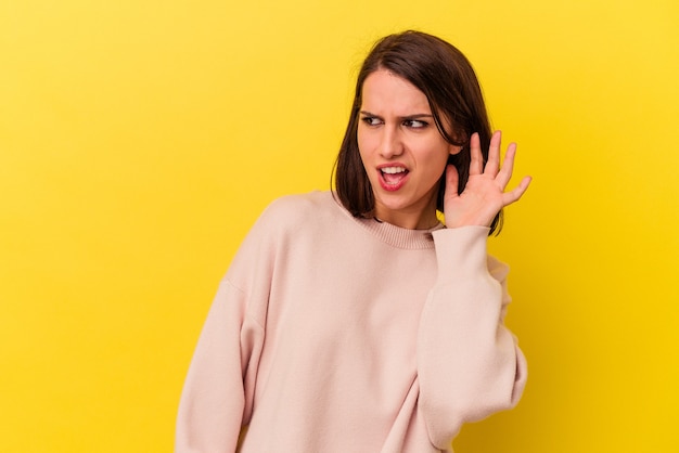 Jeune femme caucasienne essayant d'écouter un potin.