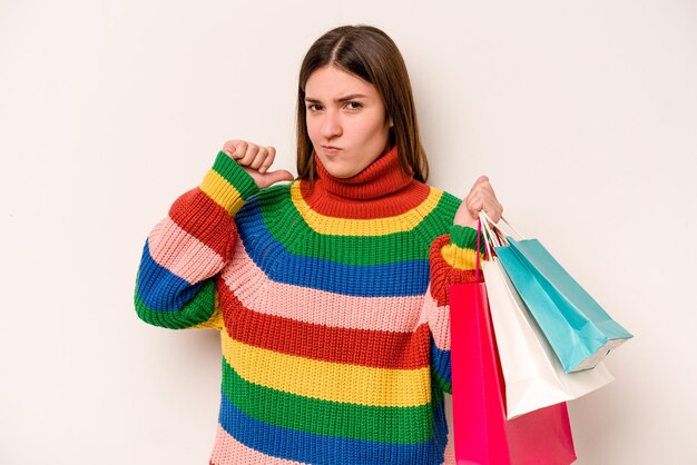 Jeune femme caucasienne faisant du shopping isolée sur fond blanc se sent fière et confiante exemple à suivre