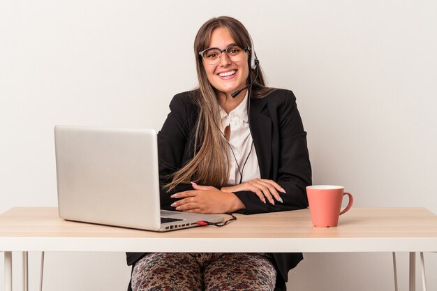 Jeune femme caucasienne faisant du télétravail isolé sur fond blanc heureuse, souriante et joyeuse.