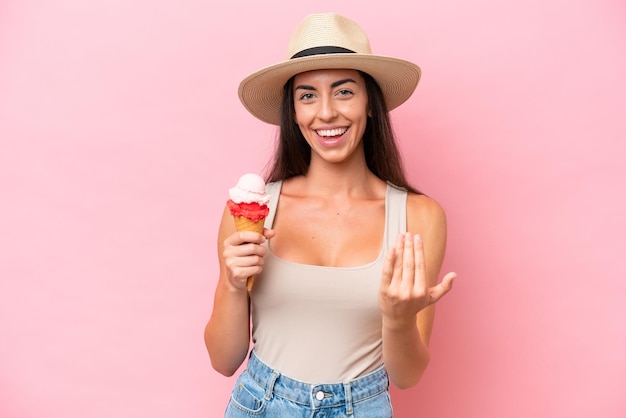 Jeune femme caucasienne avec une glace au cornet isolée sur fond rose