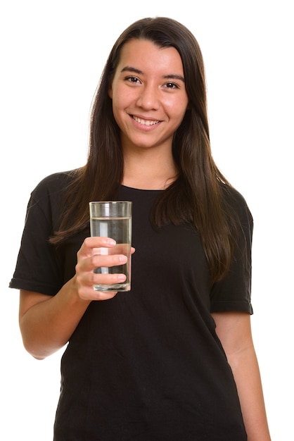 Jeune femme caucasienne heureuse souriant et tenant un verre d'eau isolé sur blanc