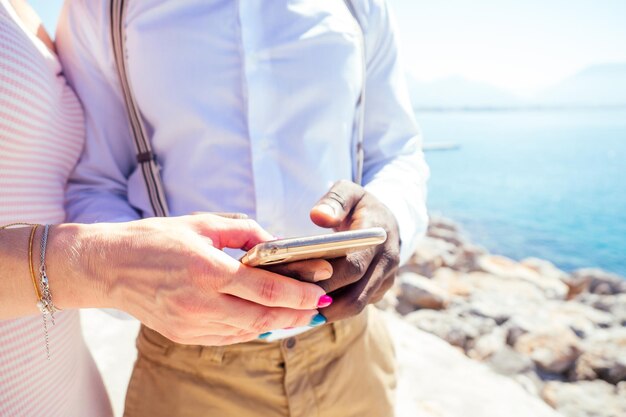 jeune femme caucasienne avec un homme afro-américain métis regardant le navigateur gps de la route du smartphone pendant les vacances d'été en Turquie.