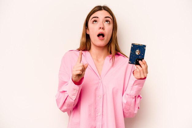 Jeune femme caucasienne informatique isolée sur fond blanc pointant vers le haut avec la bouche ouverte