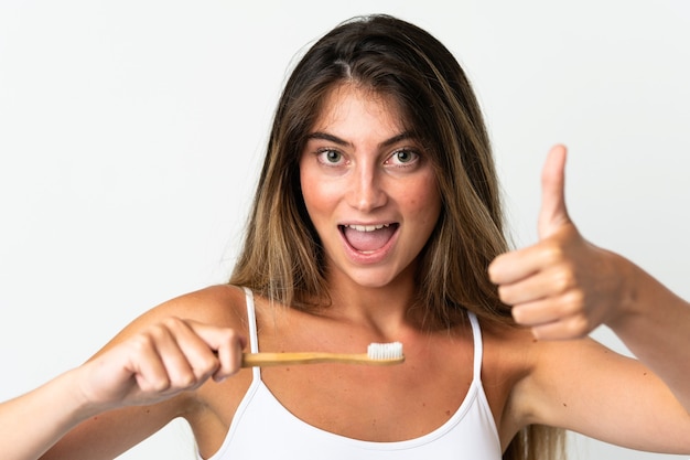 Jeune femme caucasienne isolée sur blanc avec une brosse à dents