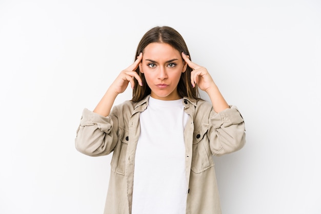 Jeune femme caucasienne isolée concentrée sur une tâche, gardant les index pointant la tête.