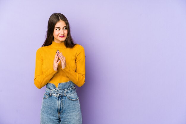 Jeune femme caucasienne isolée sur un espace violet faisant le plan à l'esprit, mettant en place une idée.