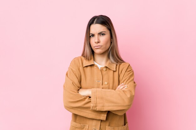 Jeune Femme Caucasienne Isolée Face Fronçant Les Sourcils De Mécontentement, Garde Les Bras Croisés.