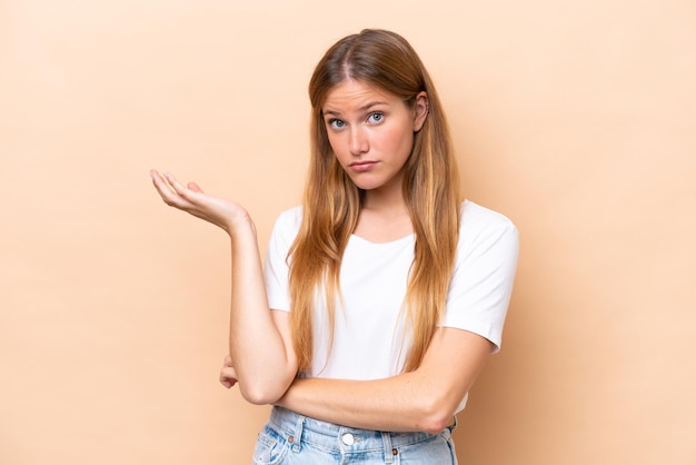 Jeune femme caucasienne isolée sur fond beige ayant des doutes