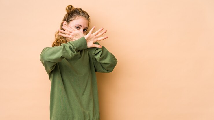 Photo jeune femme caucasienne isolée sur fond beige gardant deux bras croisés, concept de déni.