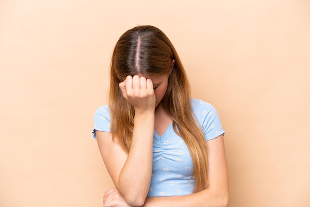 Jeune femme caucasienne isolée sur fond beige avec mal de tête