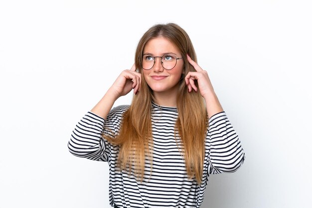 Jeune femme caucasienne isolée sur fond blanc ayant des doutes et pensant