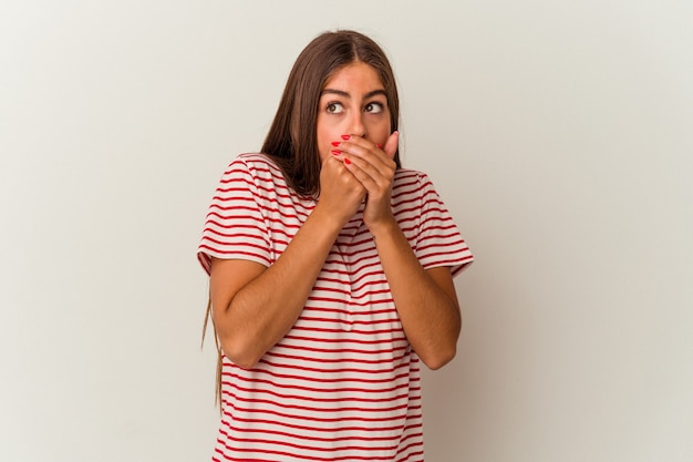 Jeune femme caucasienne isolée sur fond blanc choquée à cause de quelque chose qu'elle a vu.