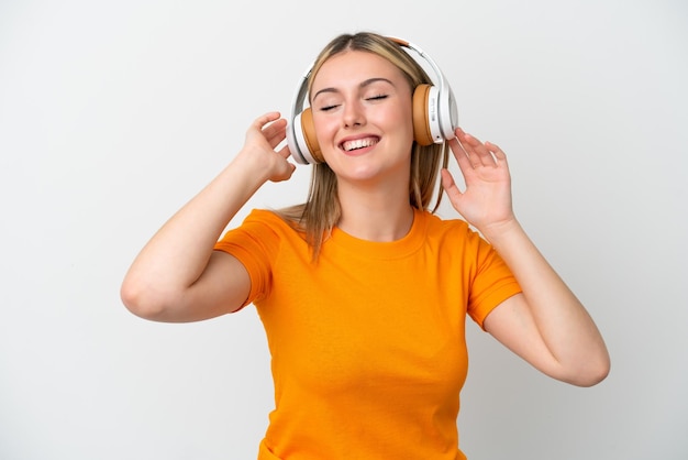 Jeune femme caucasienne isolée sur fond blanc écoutant de la musique et chantant