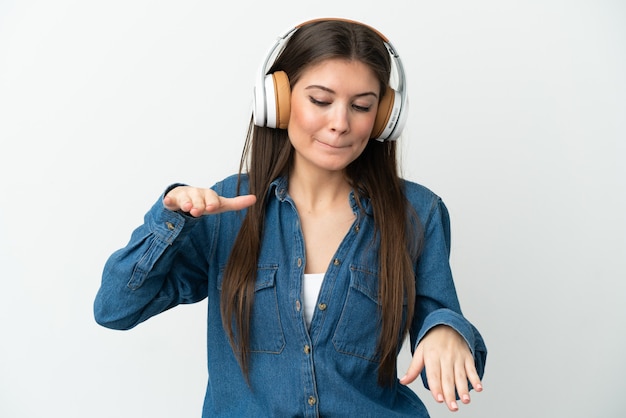 Jeune femme caucasienne isolée sur fond blanc, écouter de la musique et danser