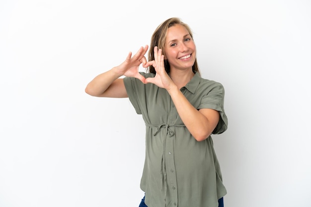 Jeune femme caucasienne isolée sur fond blanc enceinte et faisant un coeur avec les mains