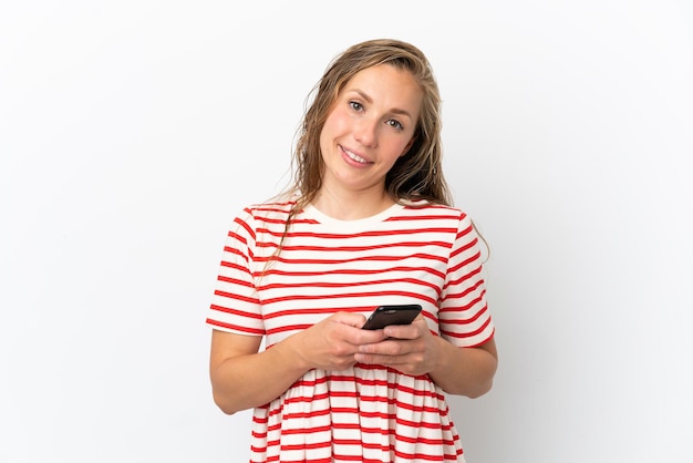 Jeune femme caucasienne isolée sur fond blanc envoyant un message avec le mobile