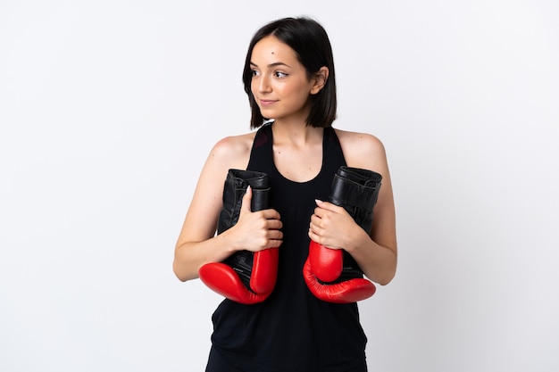 Jeune femme caucasienne isolée sur fond blanc avec des gants de boxe