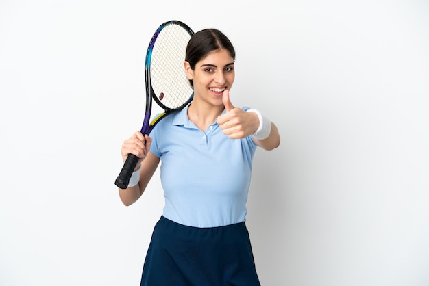 Jeune femme caucasienne isolée sur fond blanc jouant au tennis et avec le pouce vers le haut