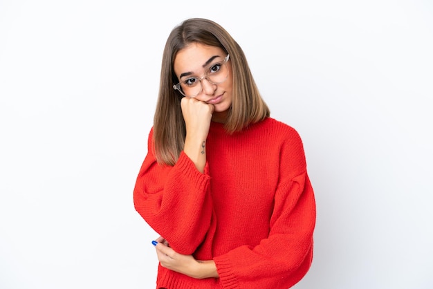 Jeune femme caucasienne isolée sur fond blanc avec des lunettes et avec une expression triste