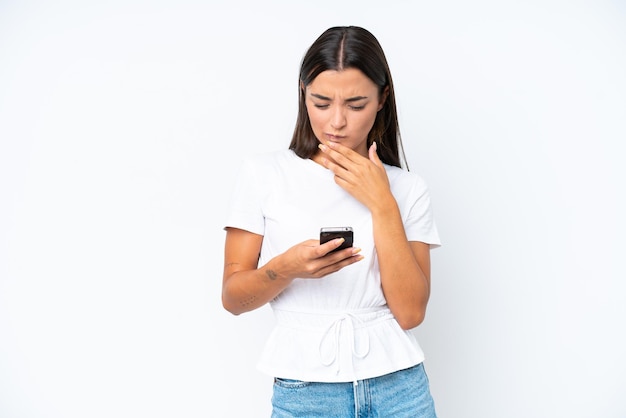 Jeune femme caucasienne isolée sur fond blanc pensant et envoyant un message