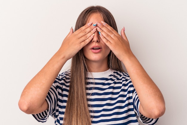 Jeune femme caucasienne isolée sur fond blanc peur couvrant les yeux avec les mains.