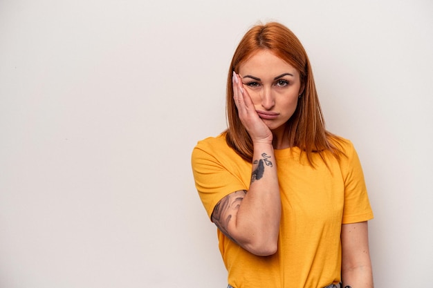 Jeune femme caucasienne isolée sur fond blanc qui se sent triste et pensive, regardant l'espace de copie.