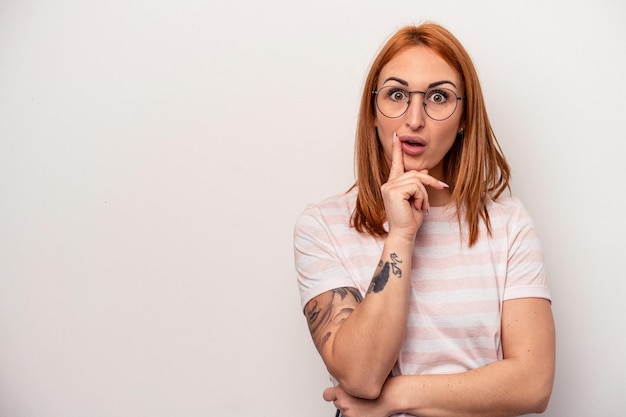 Jeune femme caucasienne isolée sur fond blanc regardant de côté avec une expression douteuse et sceptique.