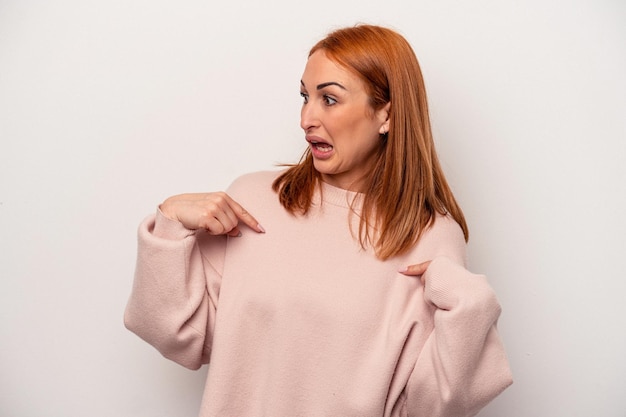 Jeune femme caucasienne isolée sur fond blanc surprise pointant du doigt, souriant largement.