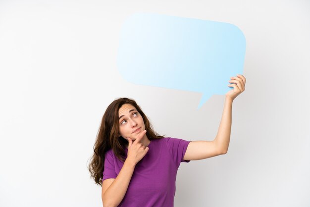 Jeune Femme Caucasienne Isolée Sur Fond Blanc Tenant Une Bulle De Dialogue Vide Et Pensant