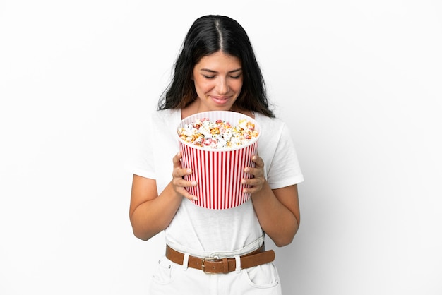 Jeune femme caucasienne isolée sur fond blanc tenant un gros seau de pop-corn