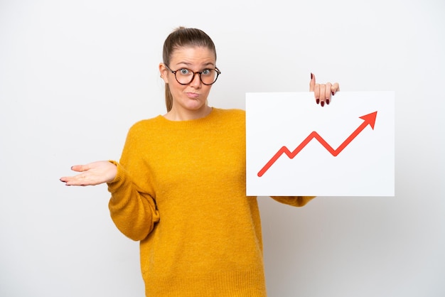 Jeune femme caucasienne isolée sur fond blanc tenant une pancarte avec un symbole de flèche de statistiques croissantes ayant des doutes