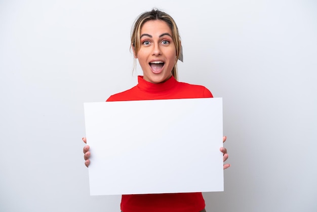 Jeune femme caucasienne isolée sur fond blanc tenant une pancarte vide avec une expression heureuse