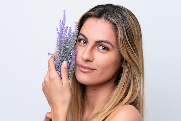 Jeune femme caucasienne isolée sur fond blanc tenant un plant de lavande Close up portrait