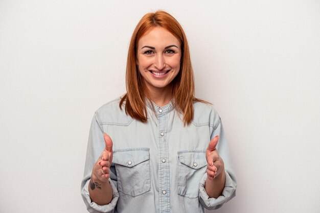 Jeune femme caucasienne isolée sur fond blanc tenant quelque chose avec les deux mains présentation du produit