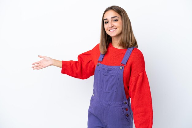 Jeune femme caucasienne isolée sur fond blanc tendant les mains sur le côté pour inviter à venir