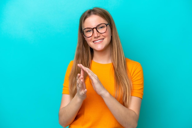 Jeune femme caucasienne isolée sur fond bleu applaudissant après présentation lors d'une conférence