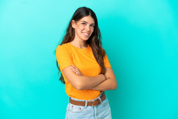 Jeune femme caucasienne isolée sur fond bleu avec les bras croisés et impatient