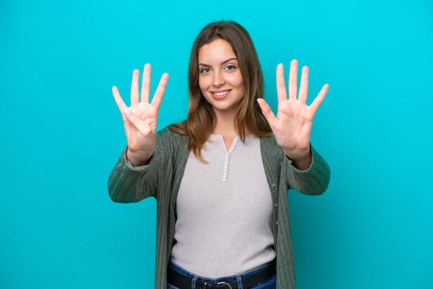 Jeune femme caucasienne isolée sur fond bleu comptant neuf avec les doigts