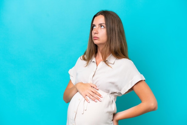 Jeune femme caucasienne isolée sur fond bleu enceinte