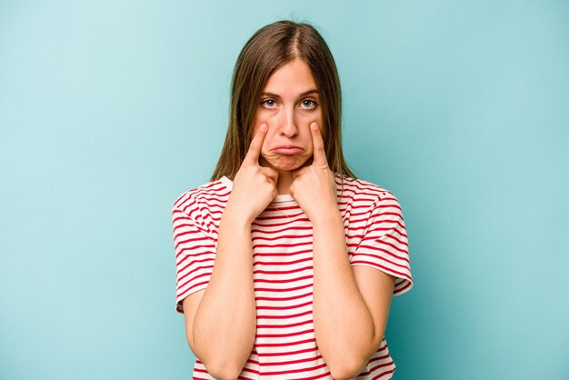 Jeune femme caucasienne isolée sur fond bleu pleurant mécontente de quelque chose d'agonie et de concept de confusion