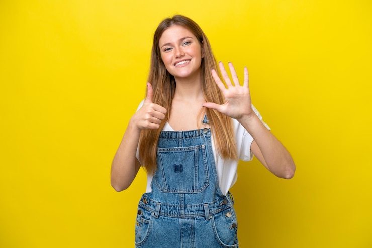 Photo jeune femme caucasienne isolée sur fond jaune comptant six avec les doigts