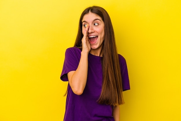 Jeune femme caucasienne isolée sur fond jaune criant excitée à l'avant.