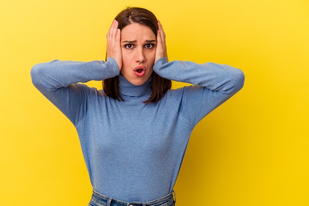 Jeune femme caucasienne isolée sur fond jaune étant choquée, elle s'est souvenue d'une réunion importante.