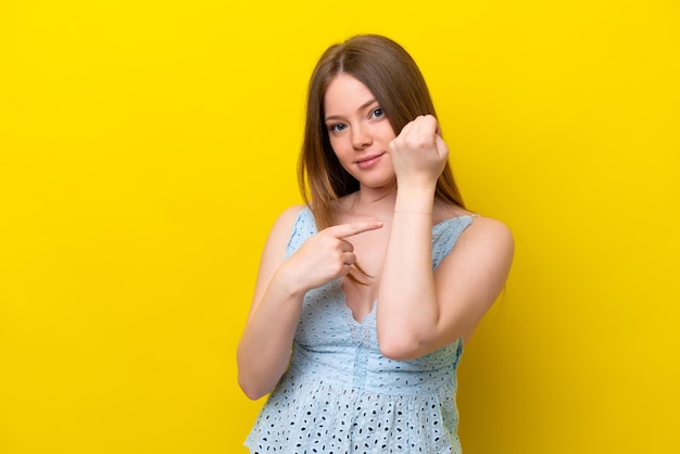 Jeune femme caucasienne isolée sur fond jaune faisant le geste d'être en retard